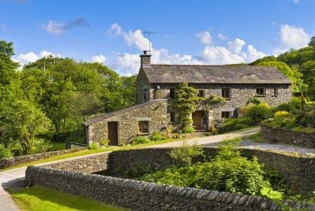 A stone farmhouse with dry-stone walls and a garden