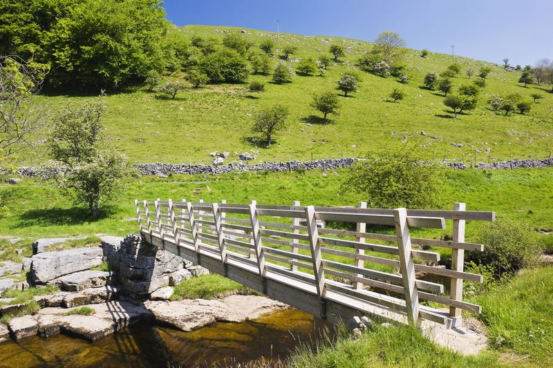 A wooden footbridge over a rocky beck
