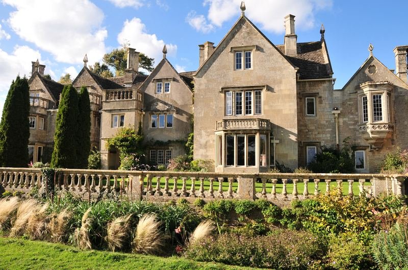A large gabled stone house above a terraced garden