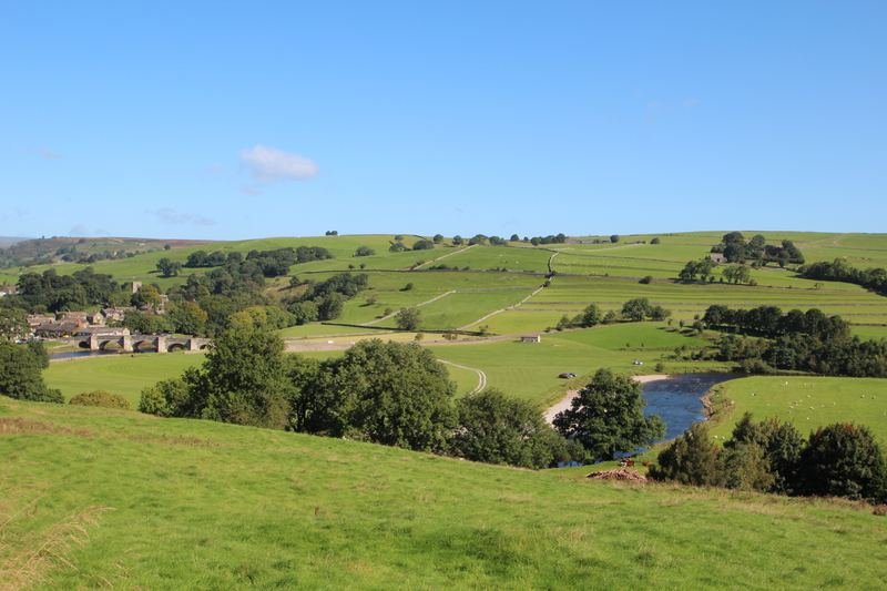 A river and stone bridge in a Dales valley of walled fields